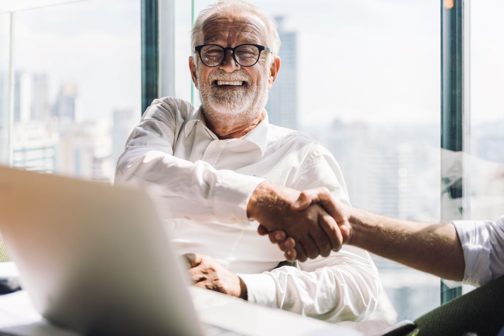 Senior businessman shaking another man hand 