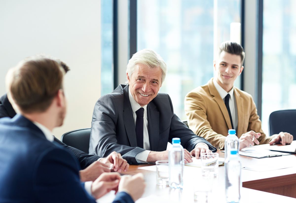 Senior businessman listening to colleagues at meeting
